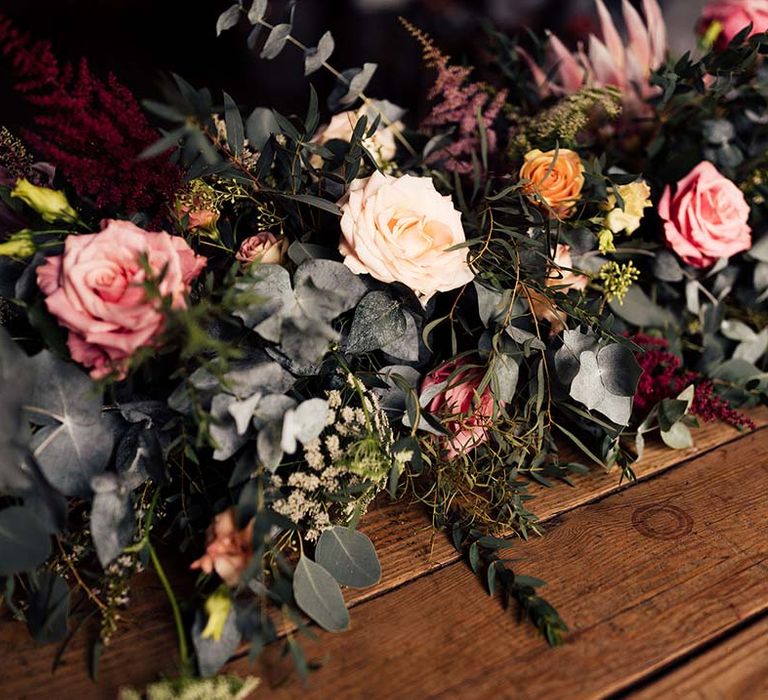 peach and pink roses and foliage wedding flower arrangement 