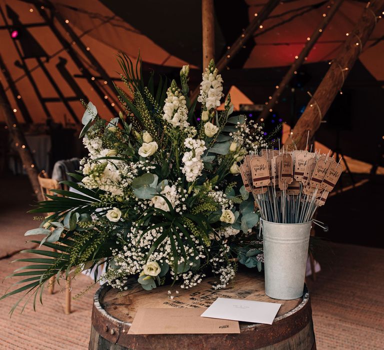 Personalised wedding sparklers next to white and green florals for festival style tipi wedding