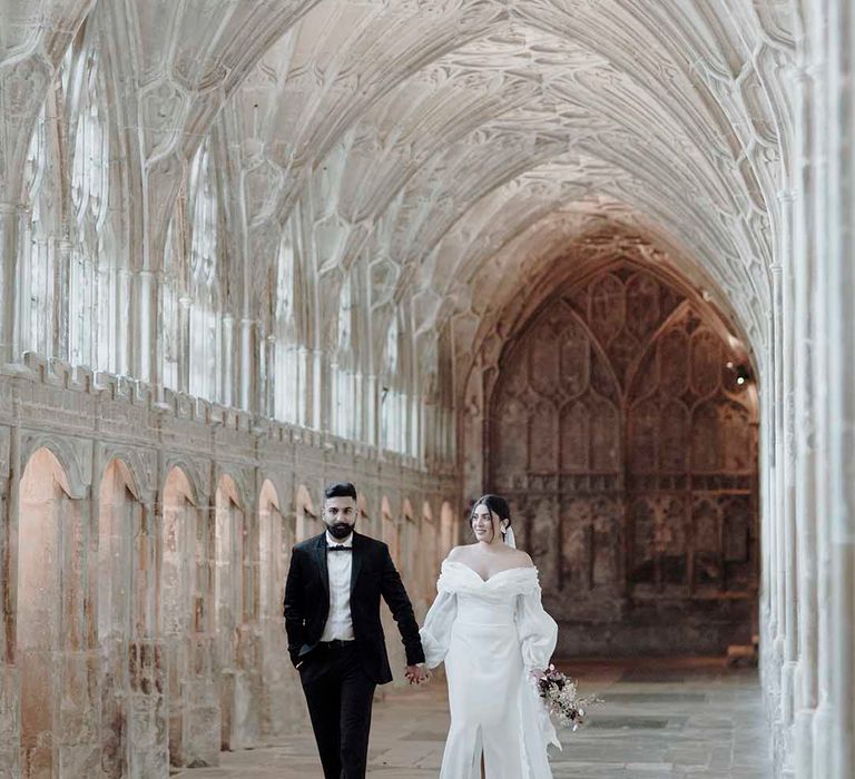 Groom in a tuxedo and bride in an off the shoulder wedding dress with long sleeves at historic wedding venue Blackfriars Priory 