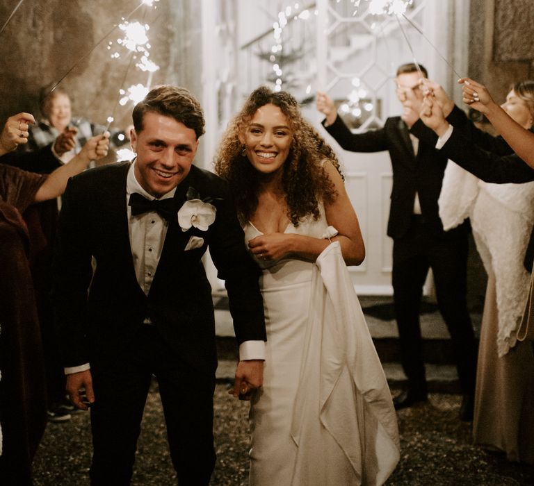 Bride & groom walk under sparklers on their wedding day 