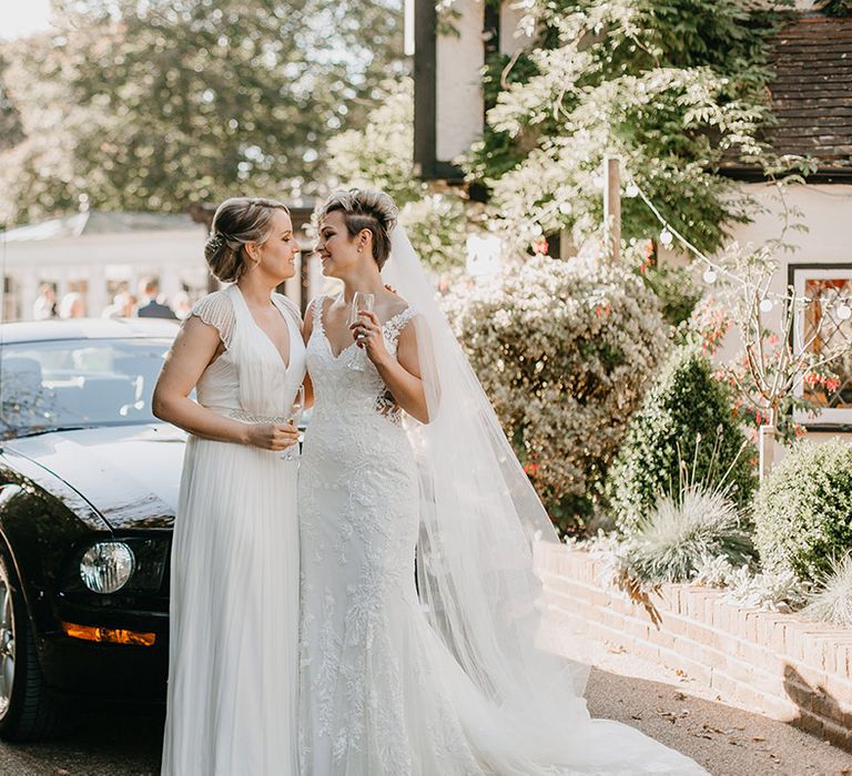 Brides kiss outdoors on their wedding day