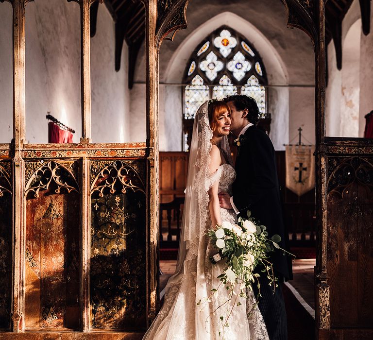 Bride and groom share a moment in the sunlight at church