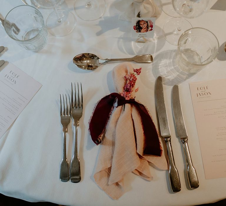 Pink and red colour scheme table setting with napkins, menu cards and name place cards with the person's face on