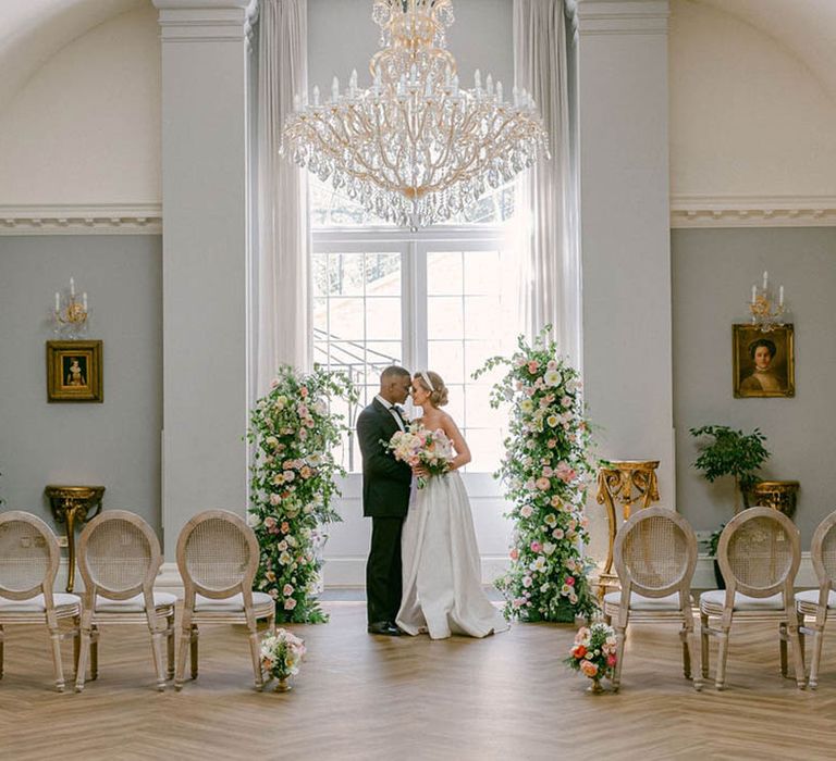 Rushton Hall wedding venue with chandeliers, flower columns and pastel details 