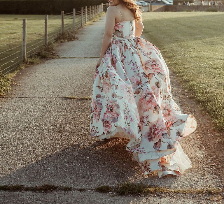 Bride runs and looks back at the camera in a hand painted silk wedding dress