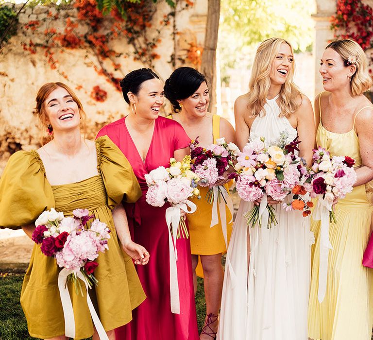 Bridal party shot with the bridesmaids in sunset tones and statement dresses for the destination wedding 