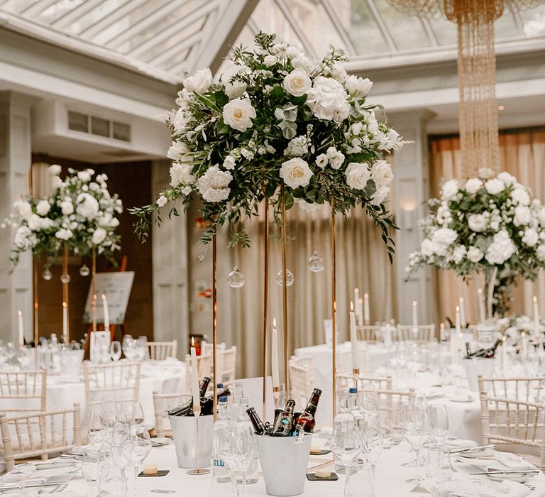 White & green flower installation centrepiece with hanging tea light candles 