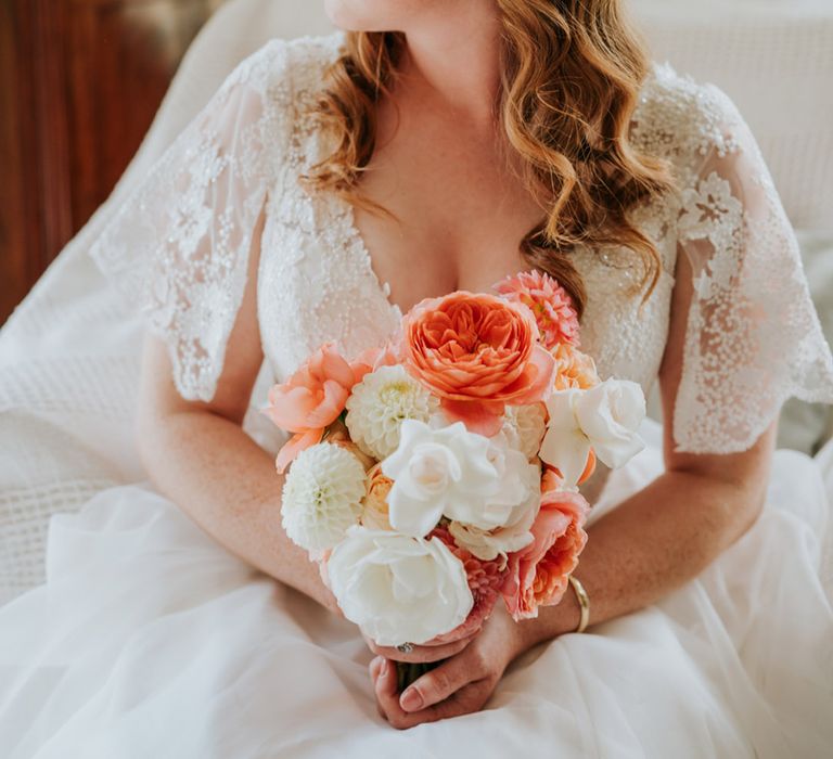 White flower wedding headband with pearls and big statement earrings holding pink and white bouquet with dahlias, peonies and roses 