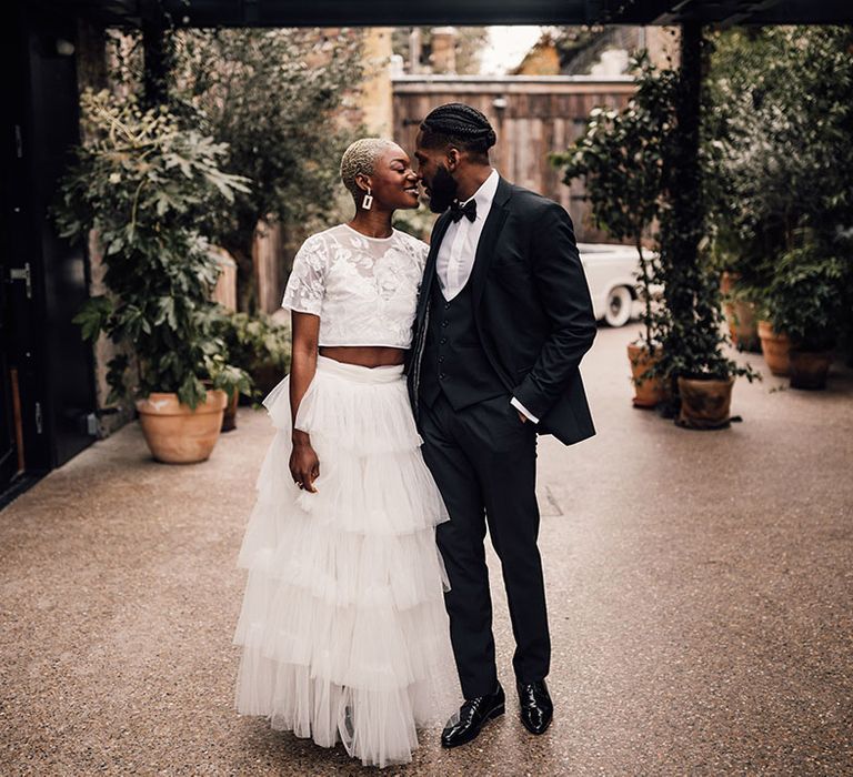 Black Bride and Groom wearing a black wedding suit and bridal two piece set at 100 Barrington in London