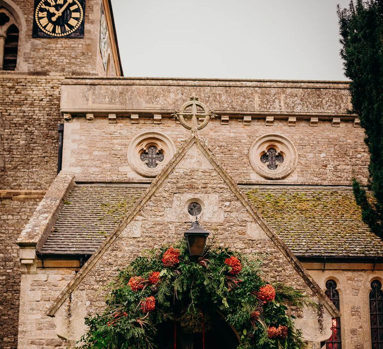 Festive red flowers decorating the church with lots of lush greenery 