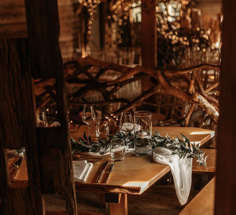 Simple wedding table setting with foliage runner and candlelight for cosy rustic treehouse wedding 