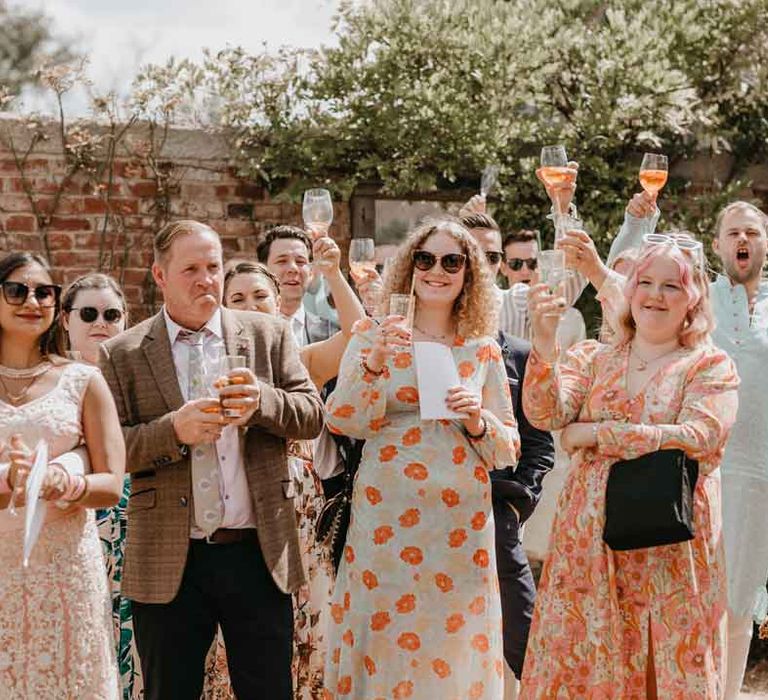 Group shot of wedding guests during the wedding speeches at Gujarati wedding ceremony LGBTQ+ at High Billinghurst Farm