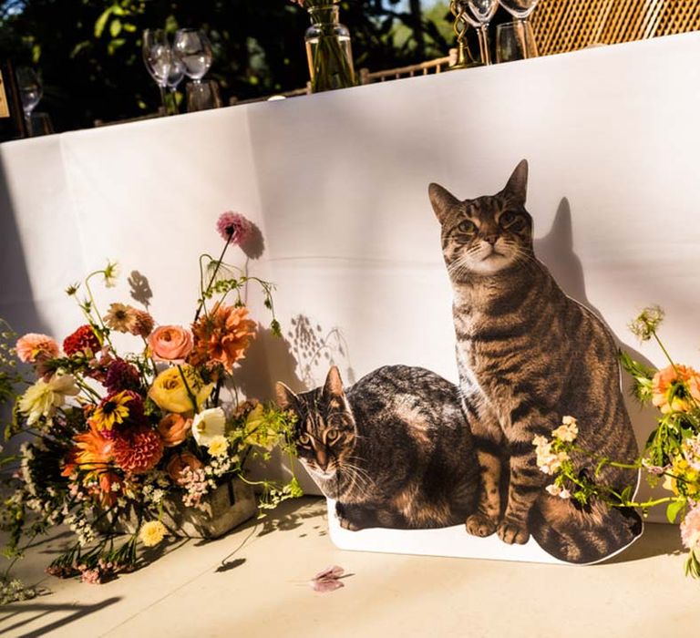 Cardboard cutouts of the couple's pet cats next to their top table 