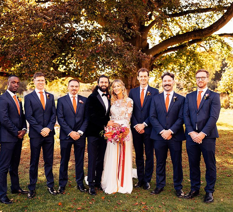 Groomsmen in navy suit with orange ties for the autumn wedding at Elmore Court with the bride and groom 