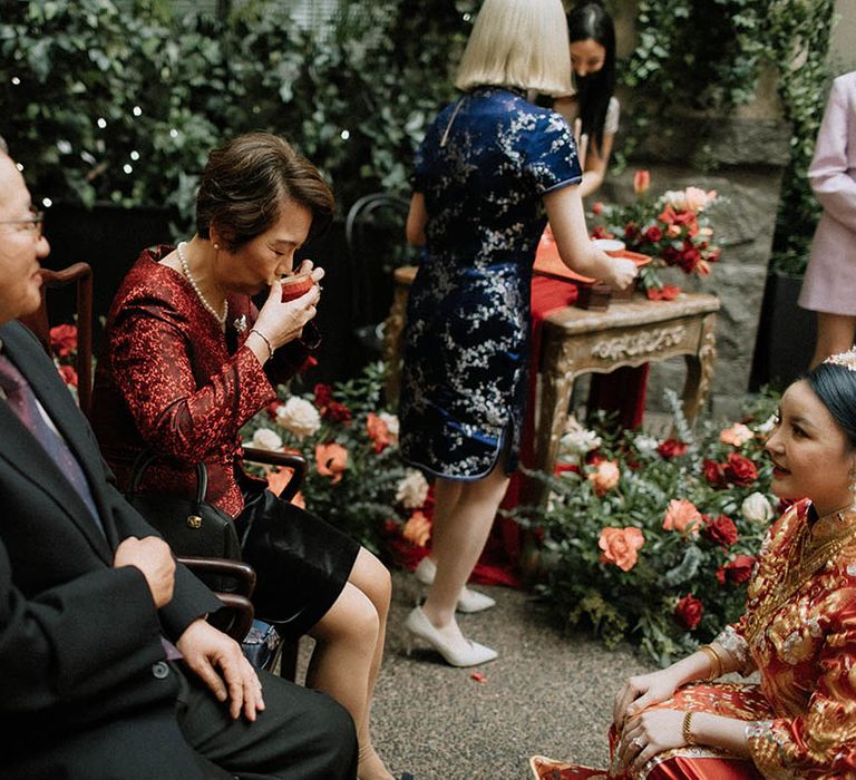 Mother and father of the groom drink tea served by the bride and groom as part of the Chinese wedding tea ceremony 