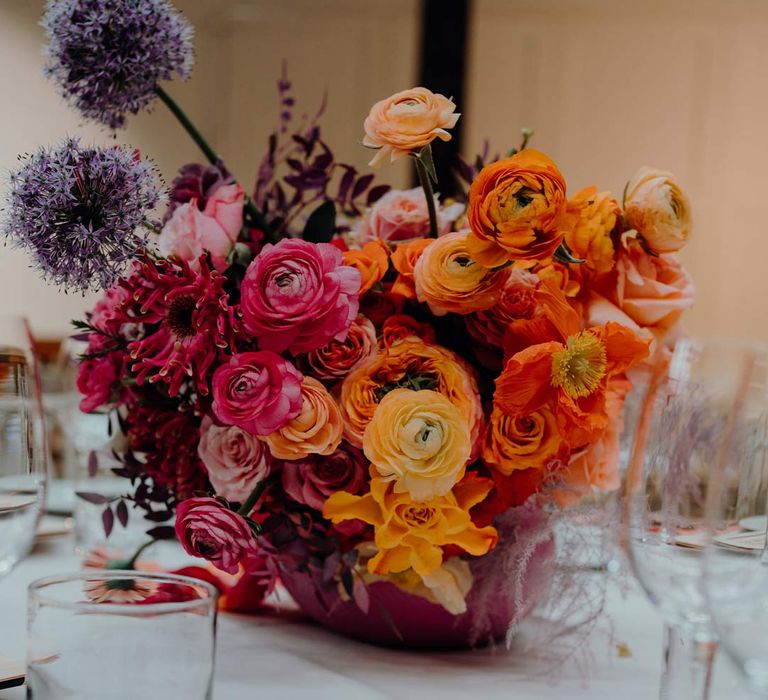 Classic wedding tablescape with floral centrepieces with peach, pink and blush garden roses, dried flowers and foliage and newspaper wedding stationery