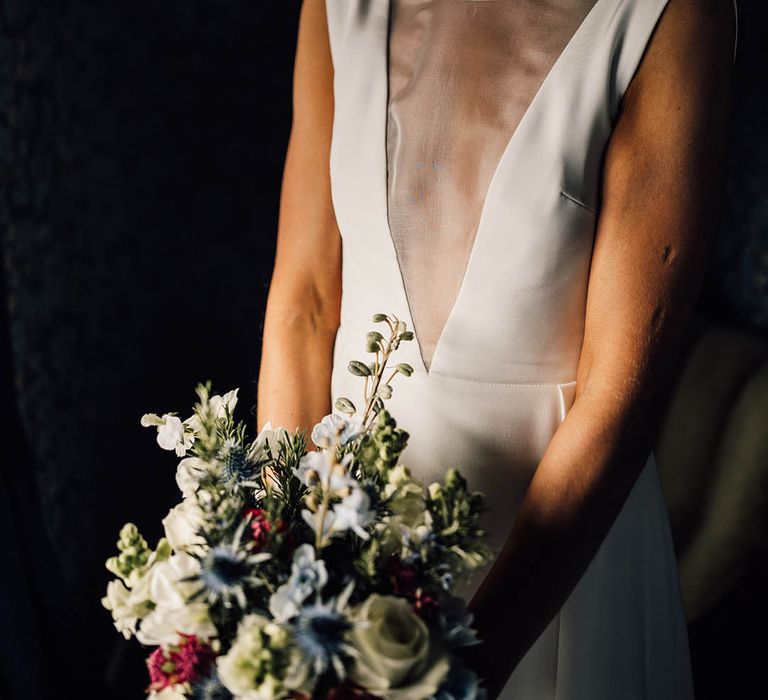 Bride holding a colourful bouquet for a spring wedding in an Andrea Hawkes wedding dress 