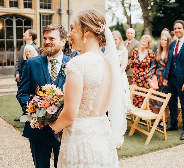 Bride holding colourful seasonal wedding bouquet for outdoor wedding ceremony 