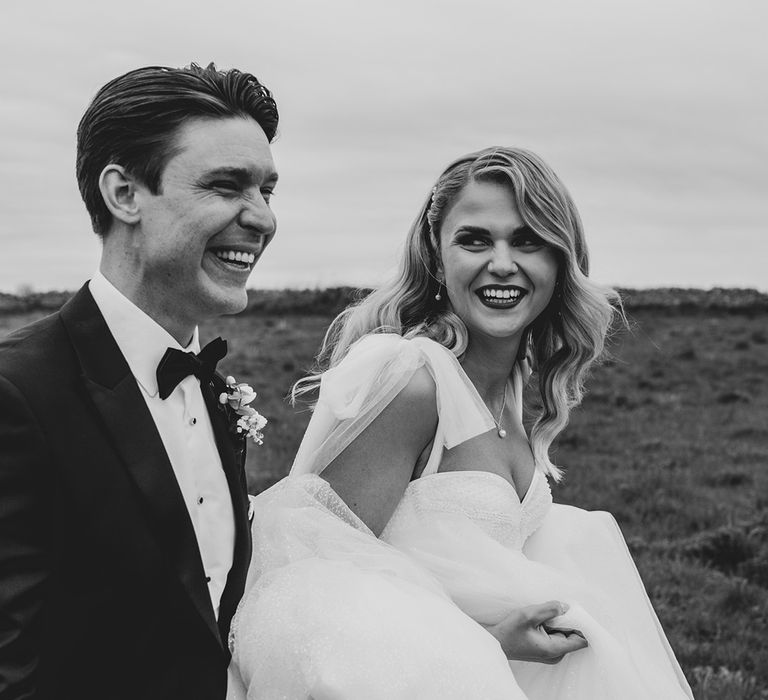 Black and white wedding couple photo of bride and groom in luxe black tie wedding outfits 