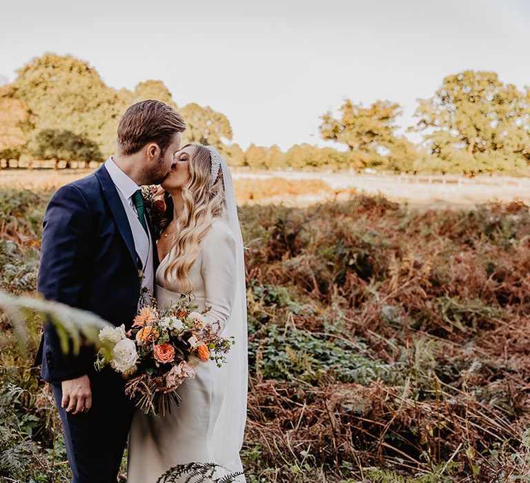 Classic Hampton Court House wedding with the bride and groom sharing an intimate kiss 