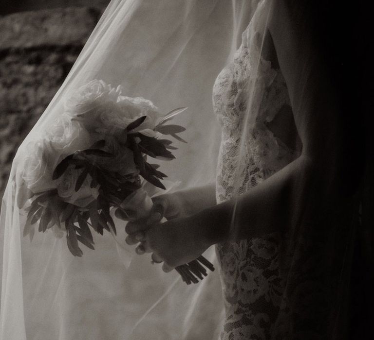 Bride holding a round white rose wedding bouquet 