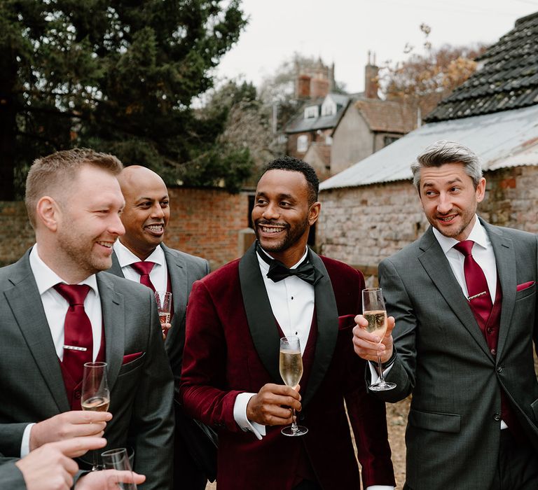 The groom and groomsmen drink champagne together on the morning of the wedding 