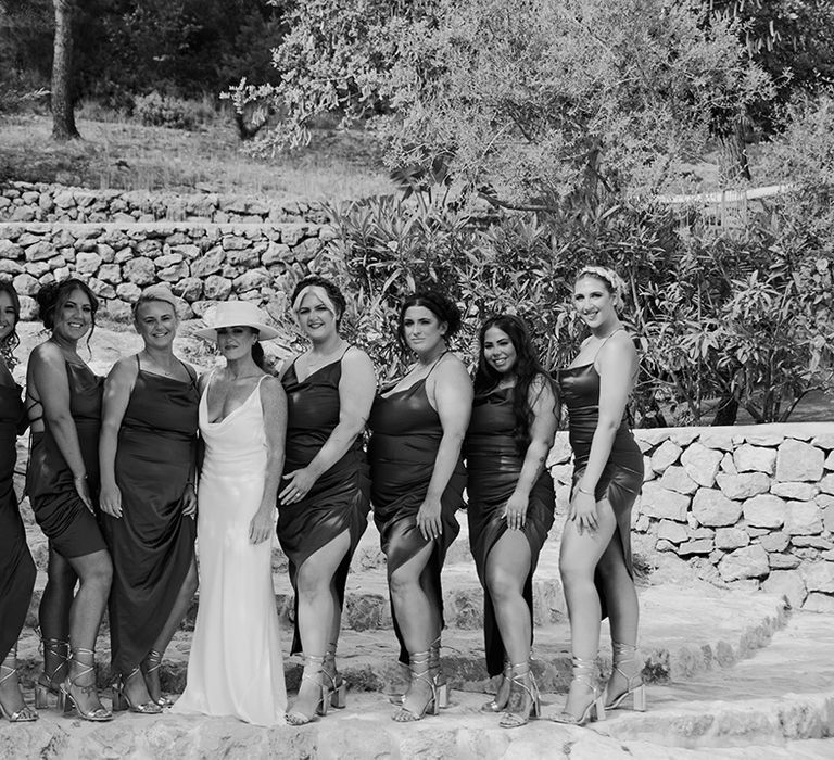 Bridal party group photo with the bridesmaids in matching satin dresses with front slit 