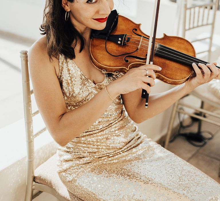 String duo in gold sequin dress playing violin 