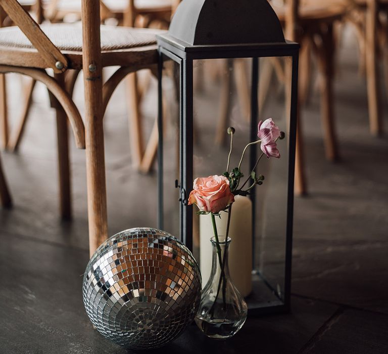 Disco ball and candle lantern decorate the aisle at the wedding at Thorpe Gardens 