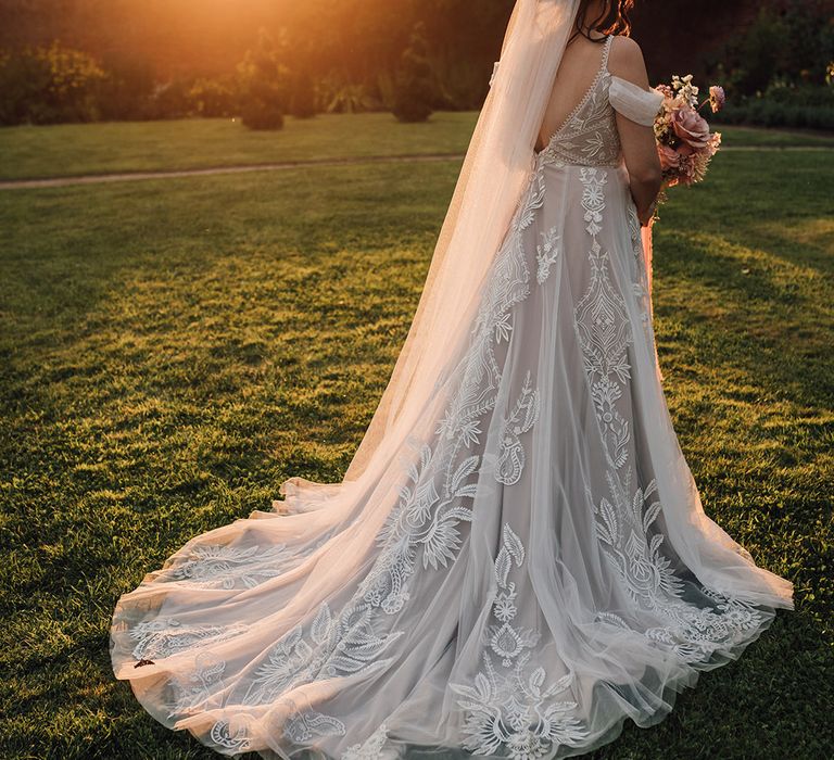 Bride in delicate lace wedding dress with train 