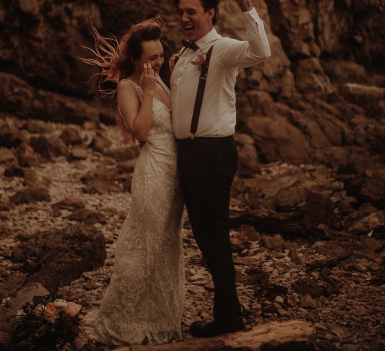 Bride in lace wedding dress and groom in braces at elopement wedding