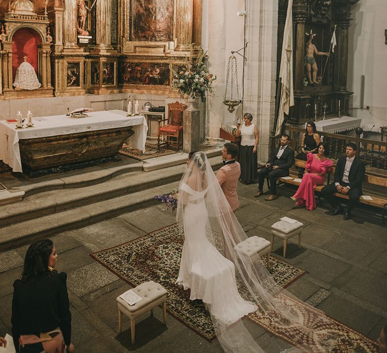 Bride and groom kneeling at church wedding ceremony 