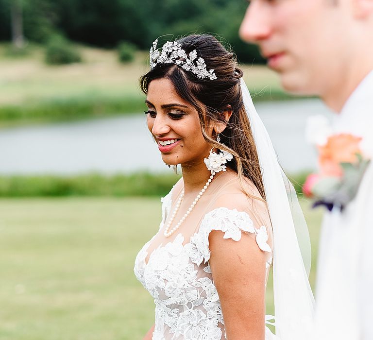 Asian bride in a Galia Lahav wedding dress with illusion neckline and appliqué detail walking with her groom 