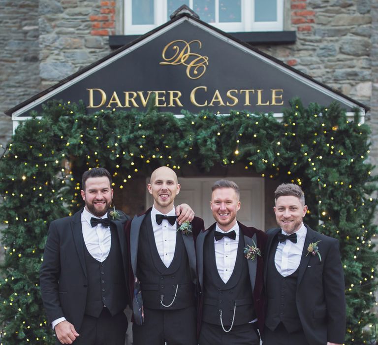 Groomsmen standing outside Darver Castle in tuxedos 