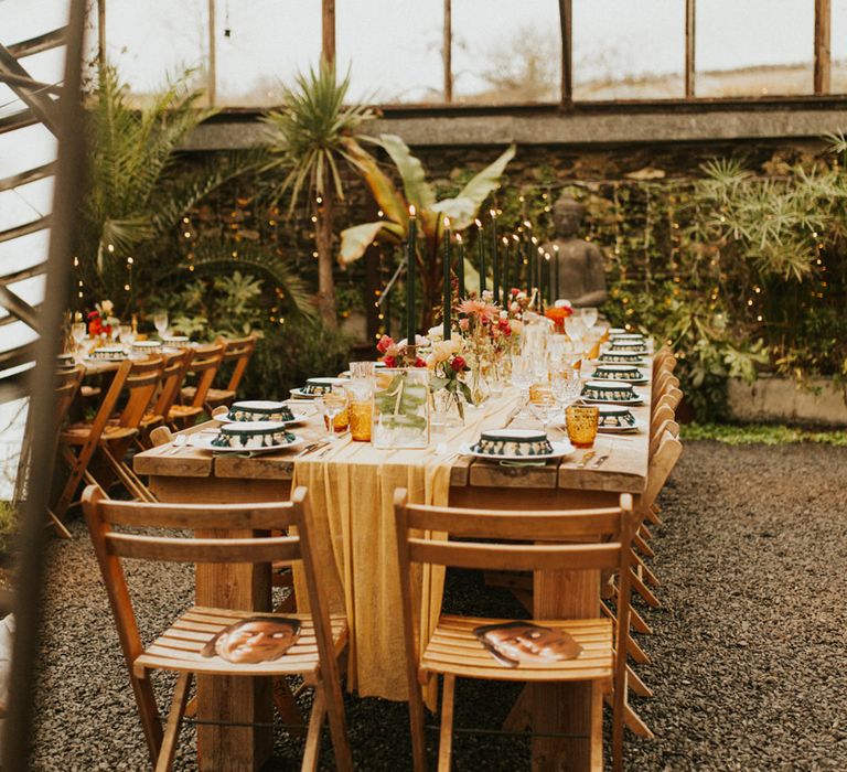 Moroccan and Autumn themed wedding table decor with green taper candles, orange coloured goblets and tambourine wedding favours 