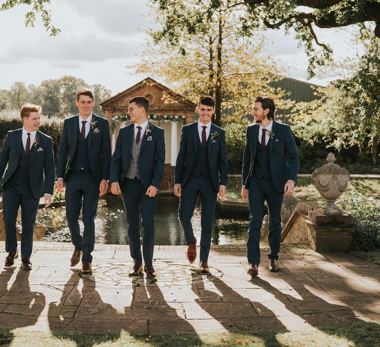 Grooms walks with his groomsmen outdoors