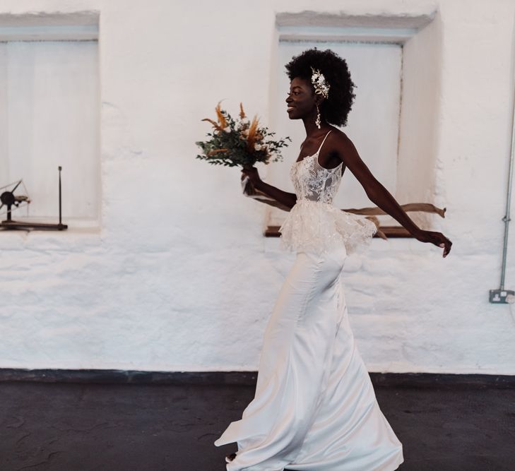 Bride in a fitted wedding dress with thin straps and lace bodice with peplum detail 