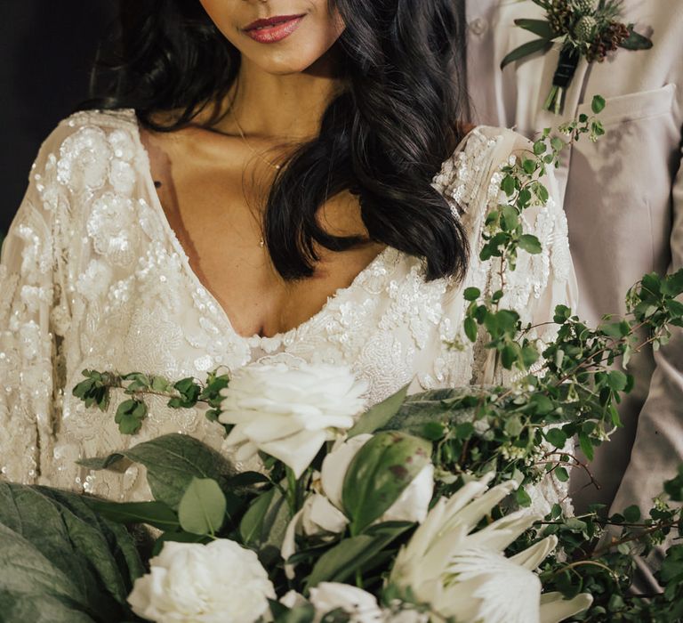 Asian bride with half up half down wavy hair and shimmering eyeshadow and lipgloss 