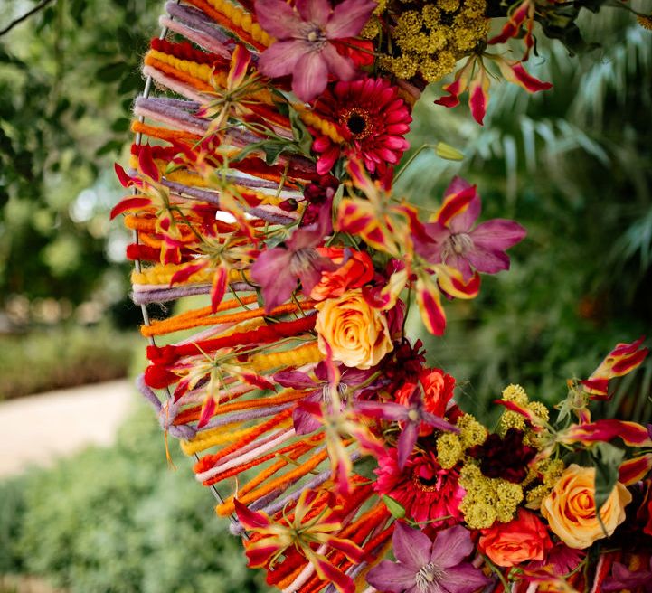 A pink and orange circular floral installation. Photography by Stephanie Shenton.