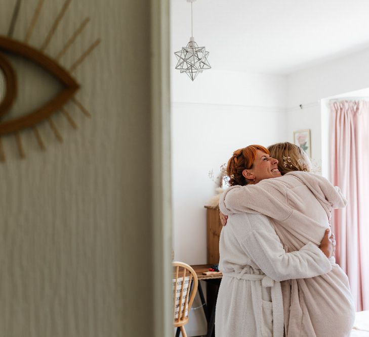 Two women hugging in dressing gowns