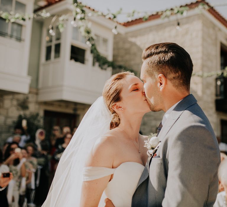 The bride and groom kiss, just married