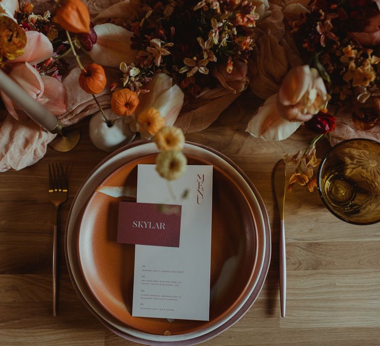 Wedding place setting with burnt orange stationery