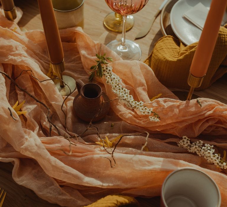 Blush linen table runner and glassware at retro boho wedding