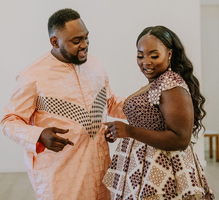 Bride & groom dance with one another in colourful outfits for third outfit change on their wedding day