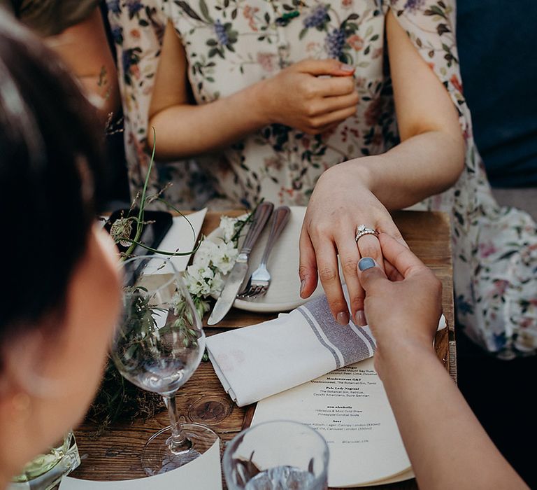 Bride showing of her diamond engagement ring and wedding band 