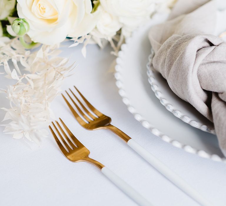 Cutlery at a black and white wedding. The handles are white and the ends gold. 