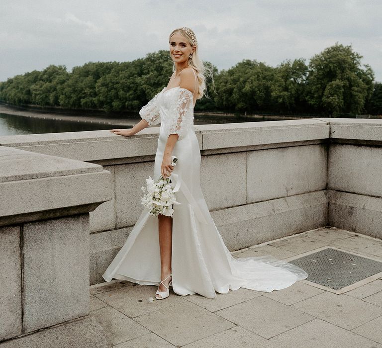 Stylish bride in a Constellation Ame satin and lace wedding dress with detachable sleeves