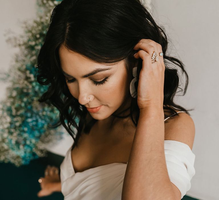 Bride with bronze shimmering eye shadow and peach lipstick in a cold shoulder wedding dress 