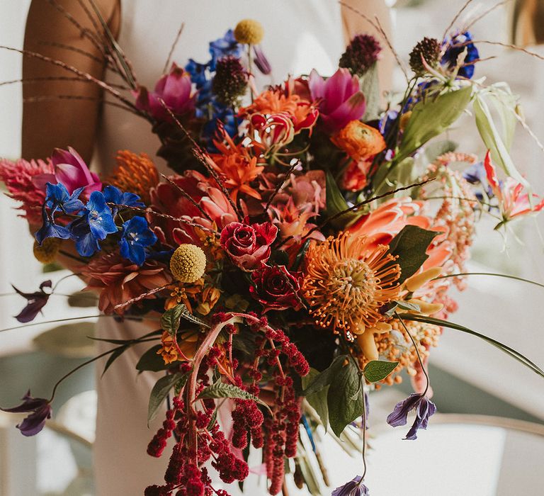 colourful wedding bouquet with billy bobs, ranunculus, roses and foliage 