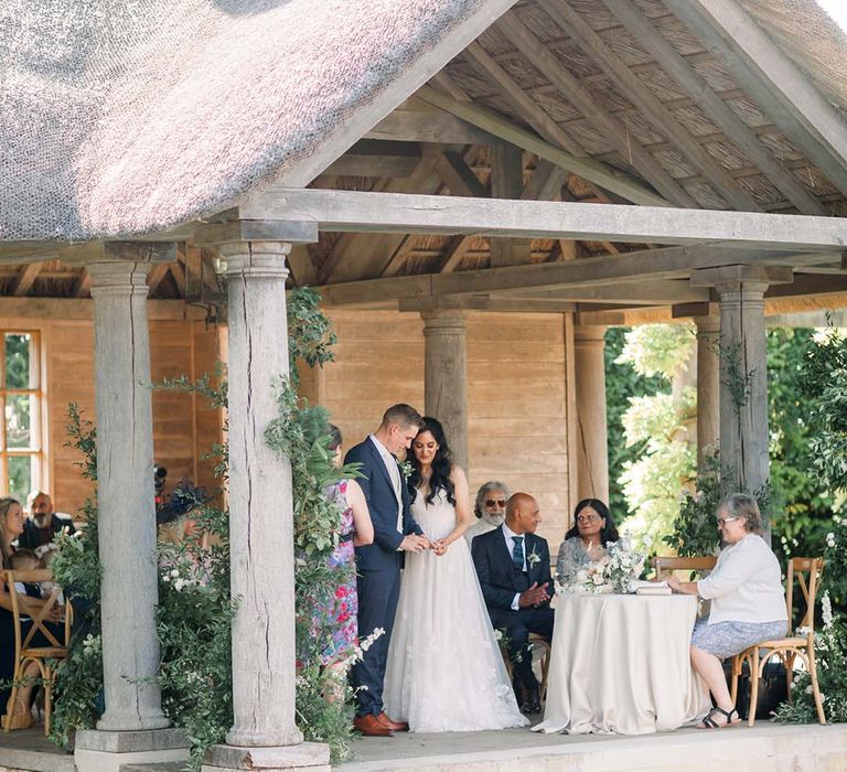 Bride & groom outdoors during their wedding ceremony at Euridge Manor